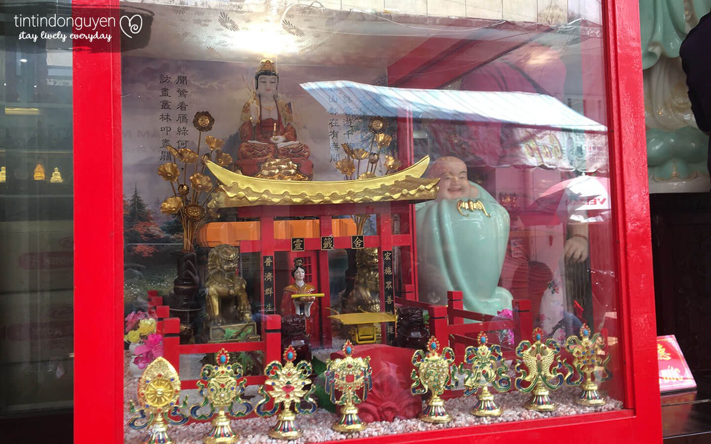 Mặt trước máy xin xăm tại chùa Vạn Phật với hình một ngồi chùa nhỏ mô hình có phật ngồi trên và cung nữ lấy xăm